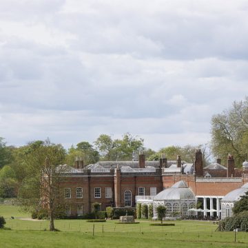 Avington House Hampshire, a grand red brick country estate surrounded by lawns and mature trees, representing trusted house sitting Hampshire