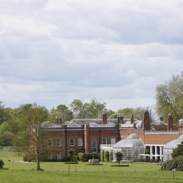 Avington House Hampshire, a grand red brick country estate surrounded by lawns and mature trees, representing trusted house sitting Hampshire
