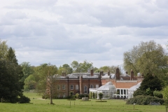Avington House Hampshire, a grand red brick country estate surrounded by lawns and mature trees, representing trusted house sitting Hampshire